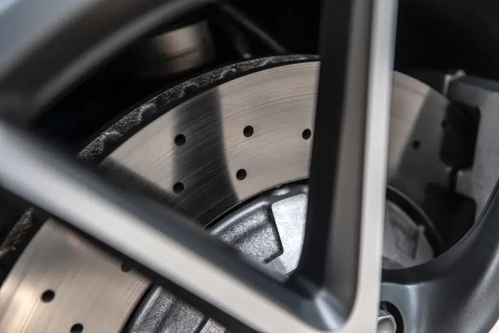 Detailansicht einer gelochten Bremsscheibe hinter einer Sportwagenfelge