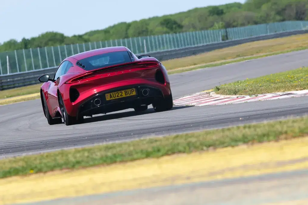 Roter Lotus Emira fährt auf einer Rennstrecke.