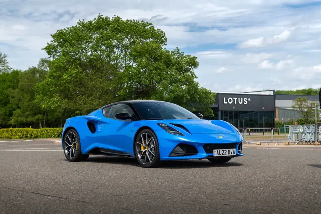 Blauer Lotus Emira Sportwagen vor dem Lotus Gebäude