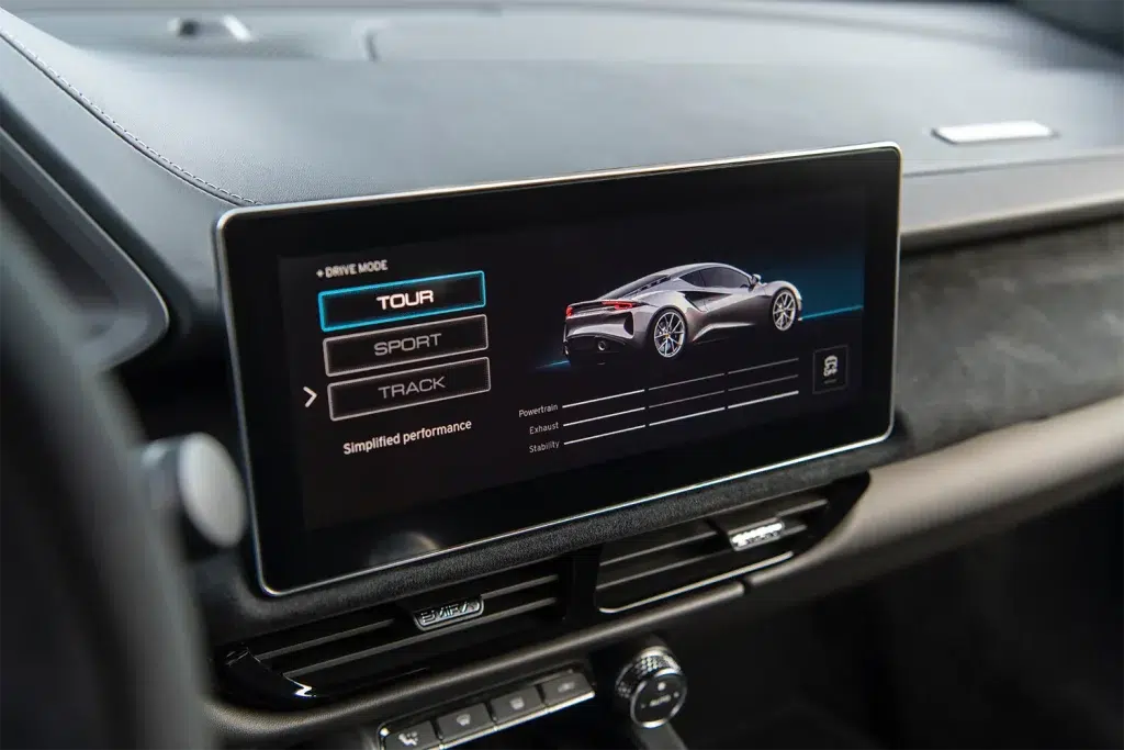 Infotainment-Bildschirm im Lotus Emira Innenraum mit Fahrmodi-Auswahl (Tour, Sport, Track).