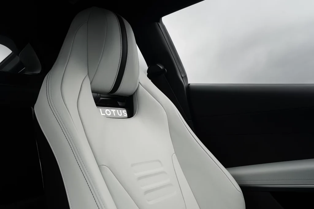 Nahaufnahme des weißen Ledersportsitzes mit Lotus-Logo im Innenraum eines Lotus Emira.