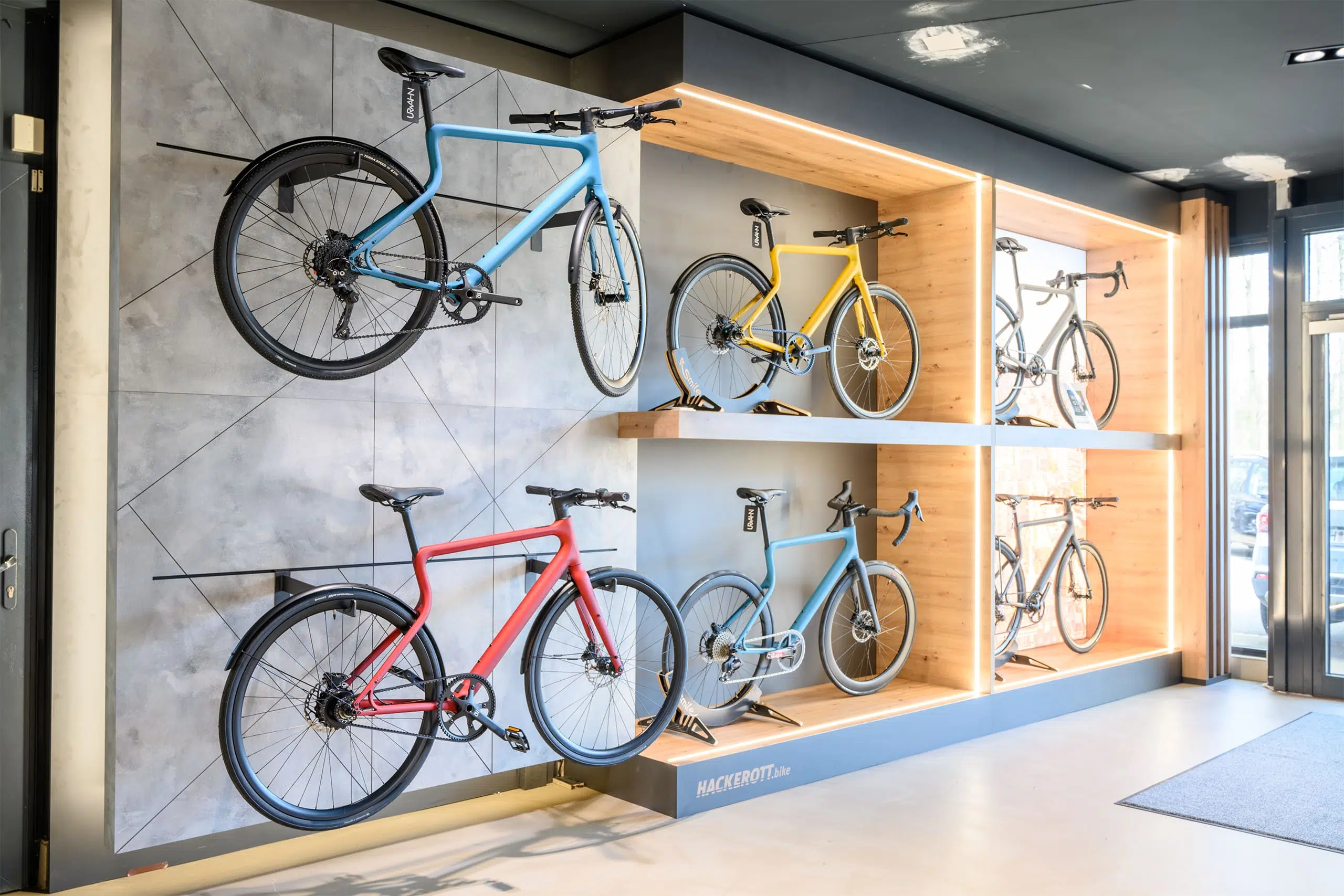 Moderne Fahrräder von Hackerott in verschiedenen Farben, ausgestellt in einem hellen Showroom.