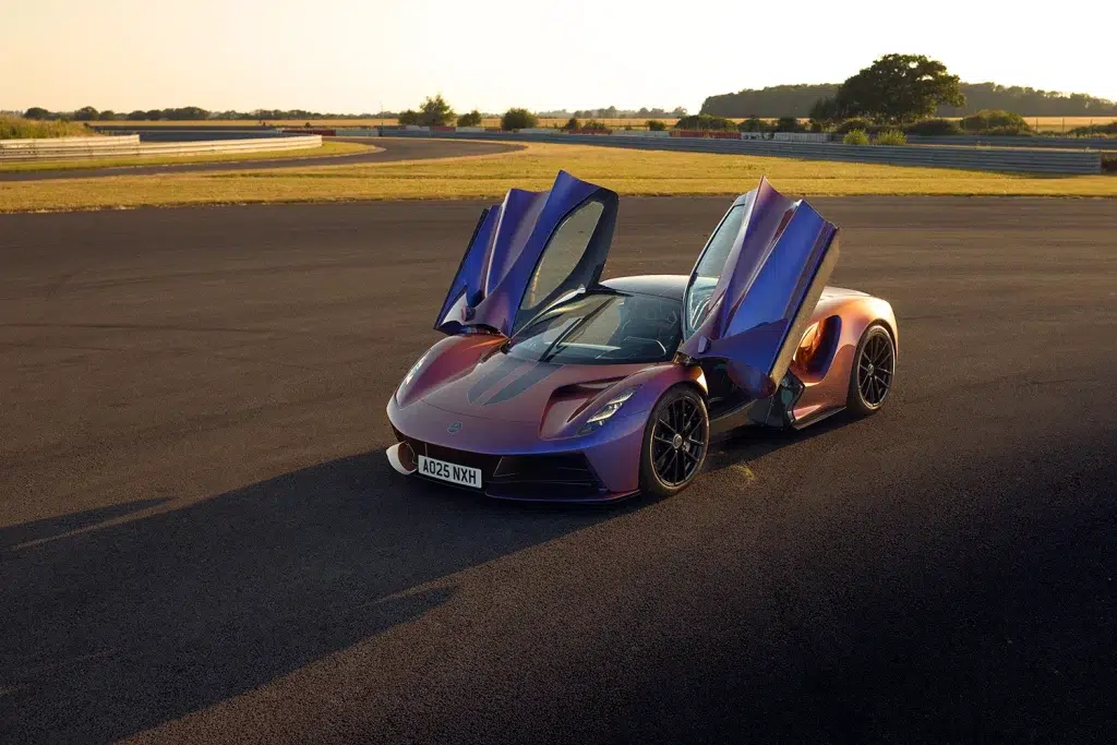 Lotus Evija in schillernder Lackierung mit geöffneten Türen auf einer Rennstrecke.