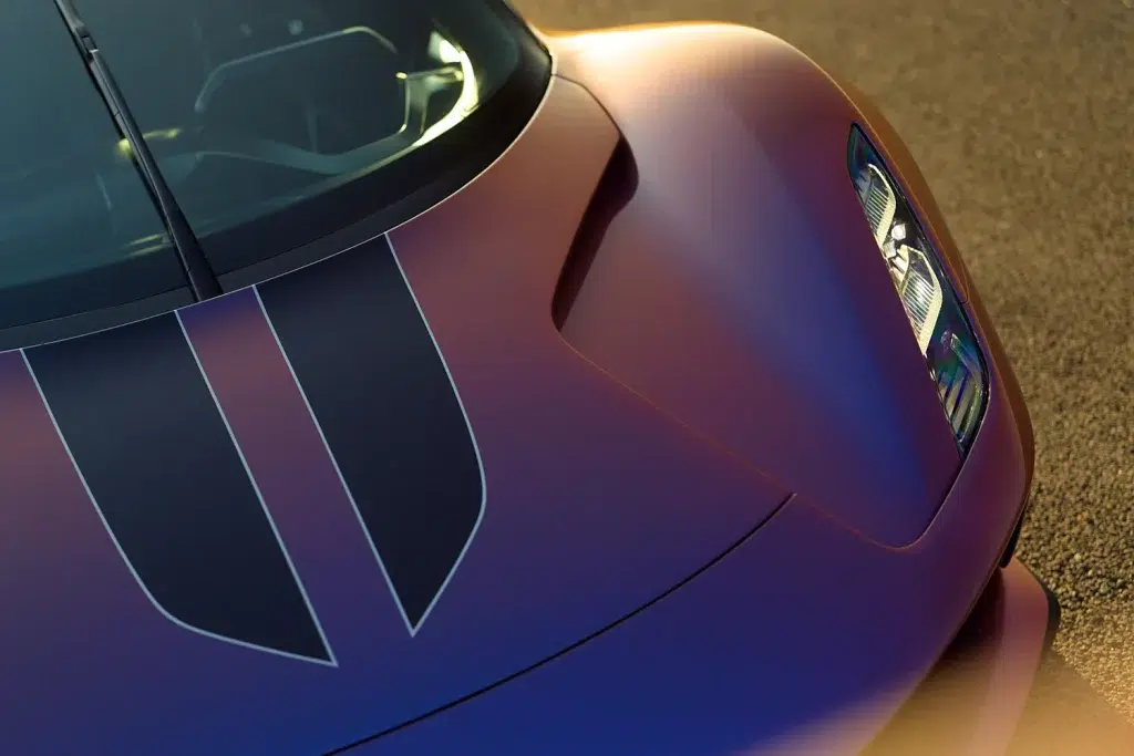 Frontpartie eines Lotus Evija in changierender Lackierung mit schwarzen Rennstreifen und LED-Scheinwerfer.