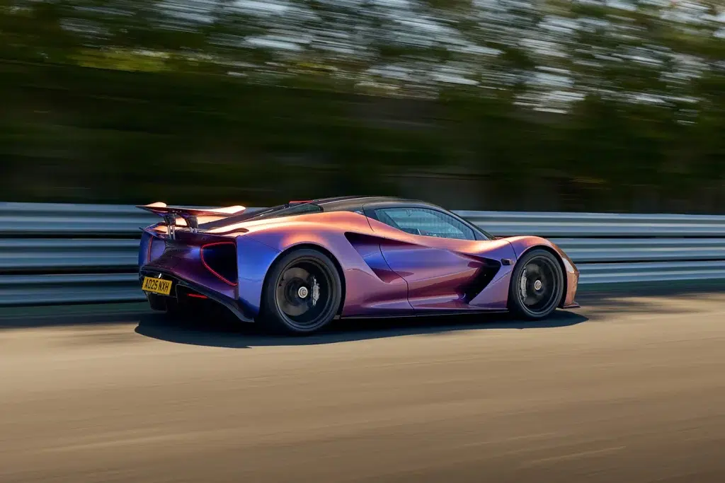 Lotus Evija in changierendem Violett-Orange, dynamisch auf einer Rennstrecke fahrend.