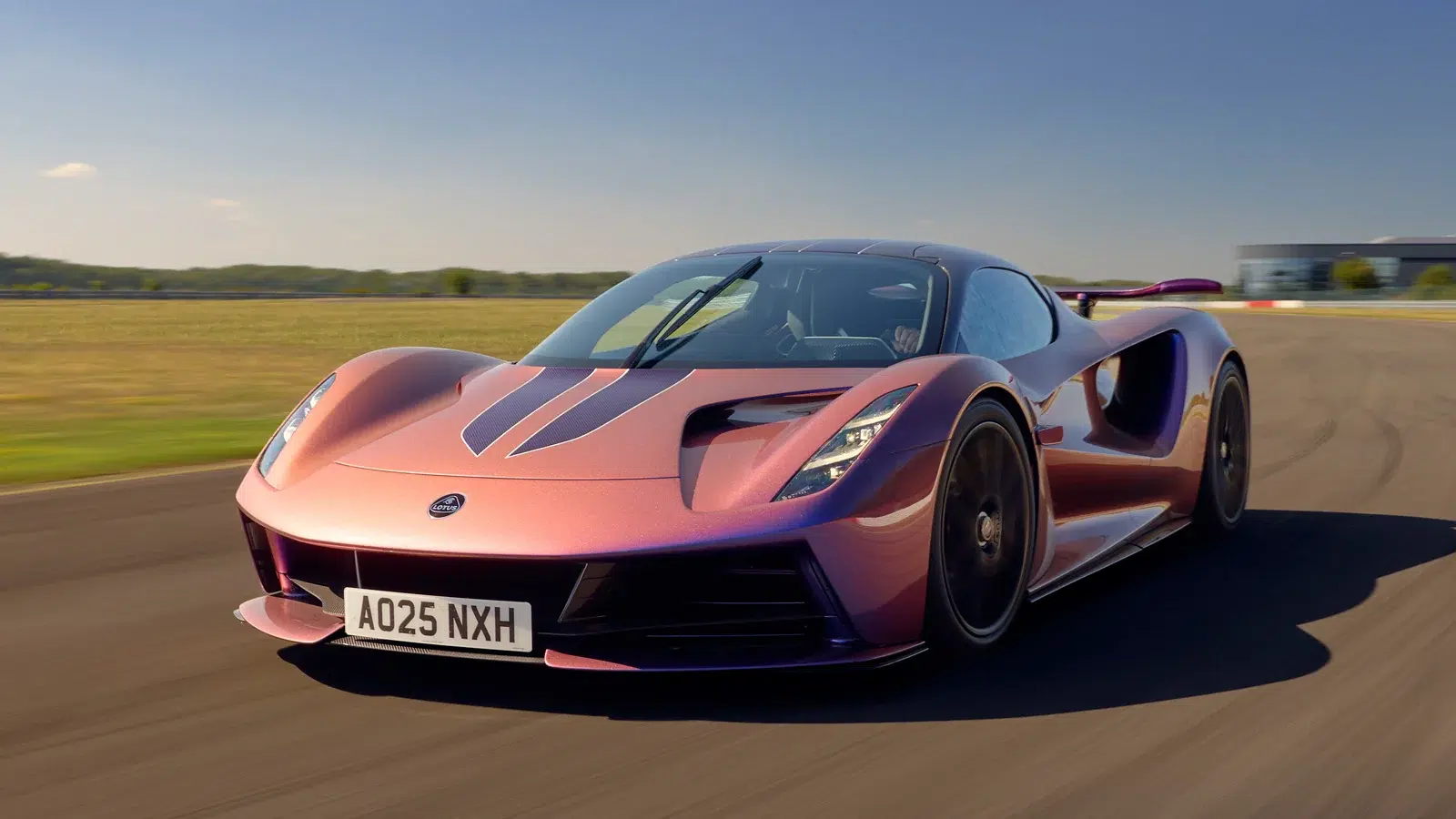Ein Lotus Evija Elektro-Hypercar in schimmerndem Rosé-Violett fährt auf einer Rennstrecke.