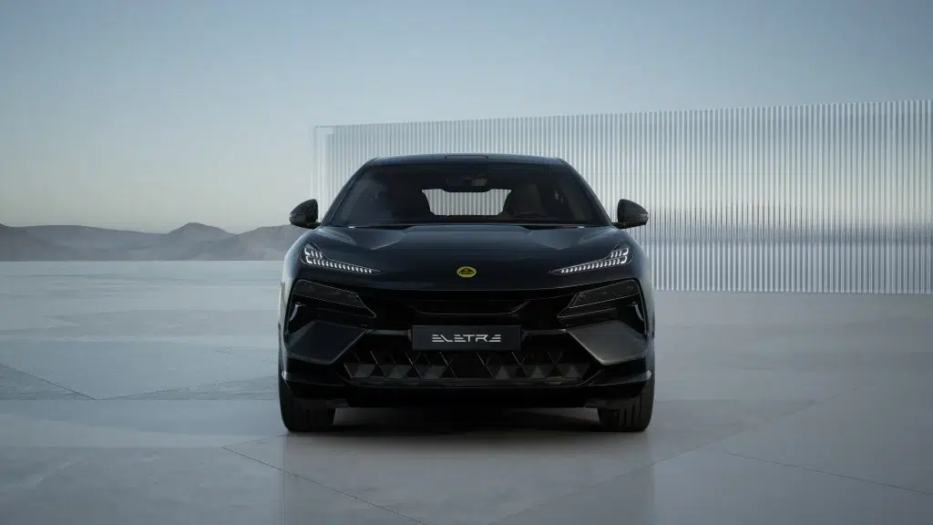 Frontansicht eines schwarzen Lotus Eletre SUV vor einer modernen Wand und einer weiten Landschaft.