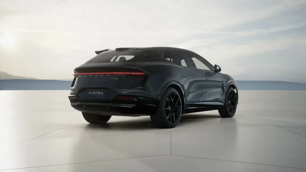 Dunkler Lotus Eletre Business Edition SUV von schräg hinten auf einer weiten, hellen Fläche.