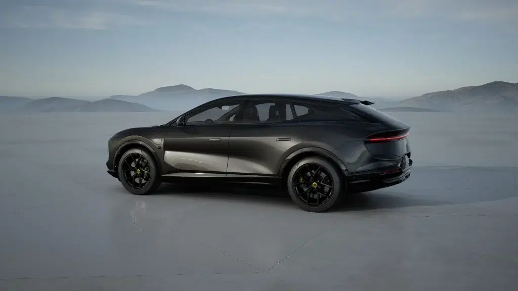 Dunkelgrauer Lotus Eletre SUV von hinten schräg links auf einer weiten Ebene vor einer Bergkette.