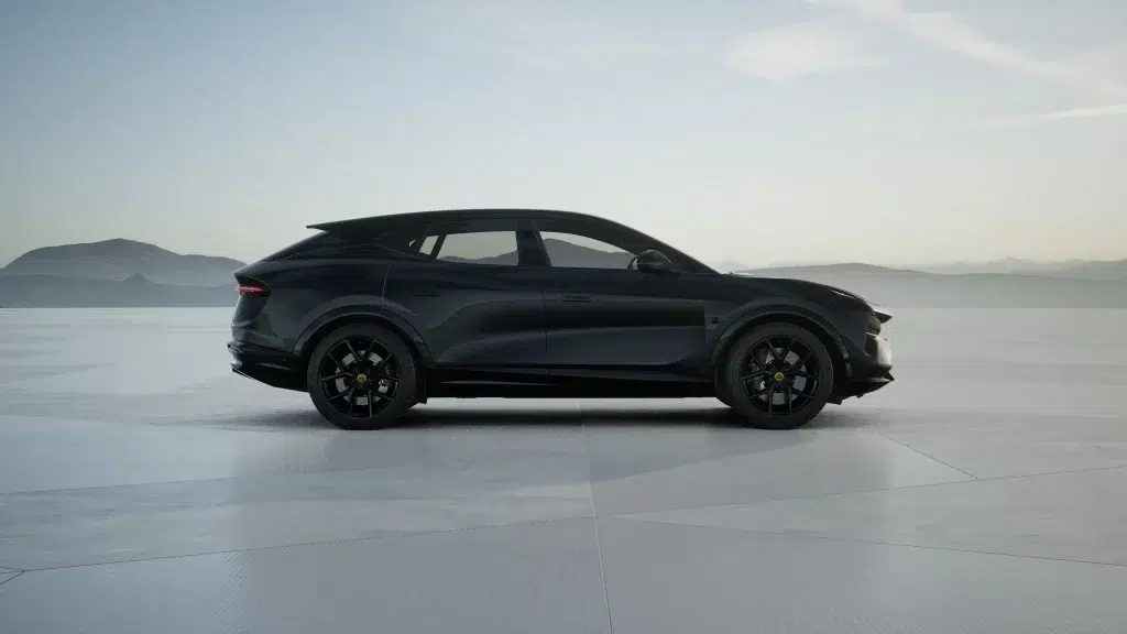 Schwarzer Lotus Eletre SUV in Seitenansicht auf einer weiten, hellen Fläche vor einer Berglandschaft.