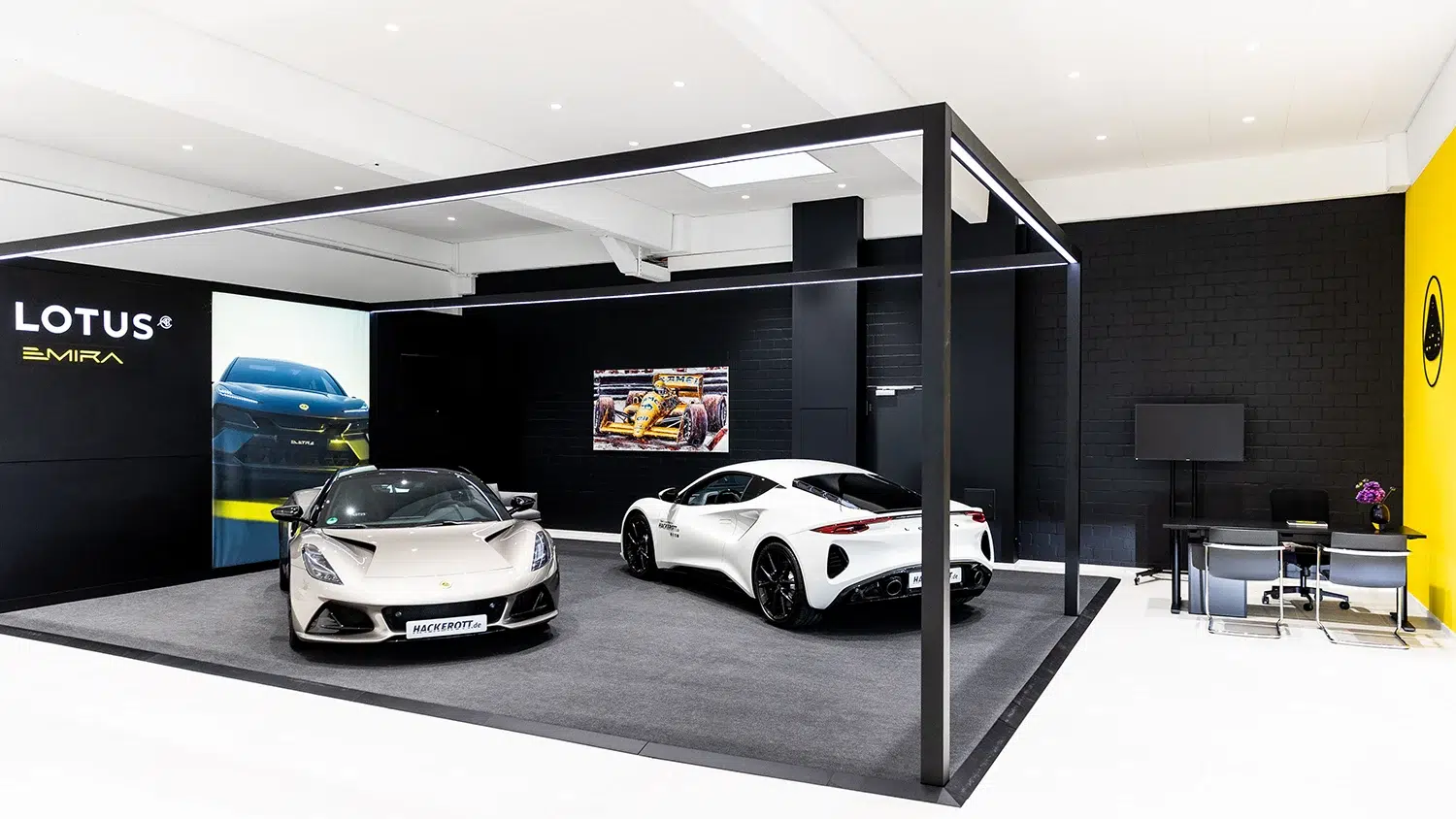 Moderner Lotus Showroom in Burgwedel mit zwei Lotus Emira Sportwagen und Markenpräsentation.