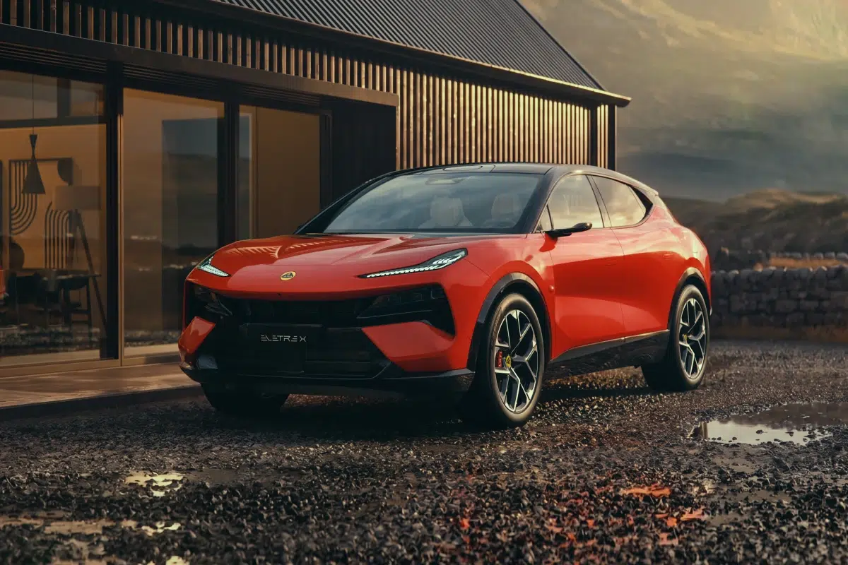 Ein roter Lotus Eletre parkt vor einem modernen Gebäude in einer Berglandschaft.