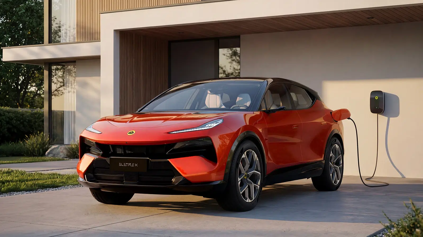 Ein roter Lotus Eletre lädt an einer Wallbox vor einem modernen Haus.