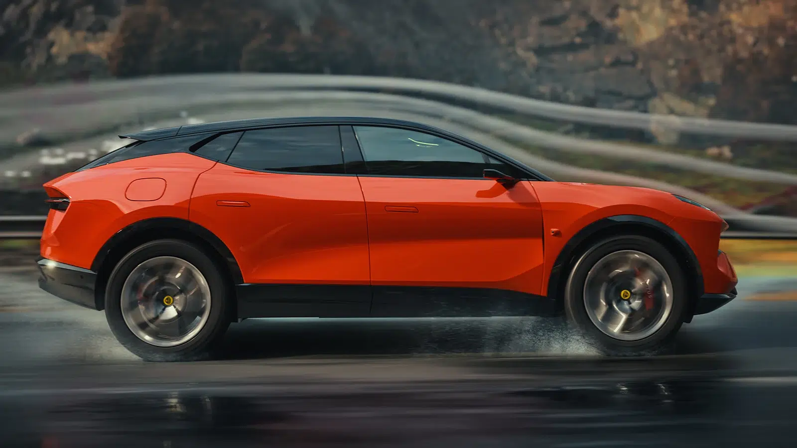 Seitenansicht eines orangefarbenen Lotus Eletre während der Fahrt auf nasser Fahrbahn.